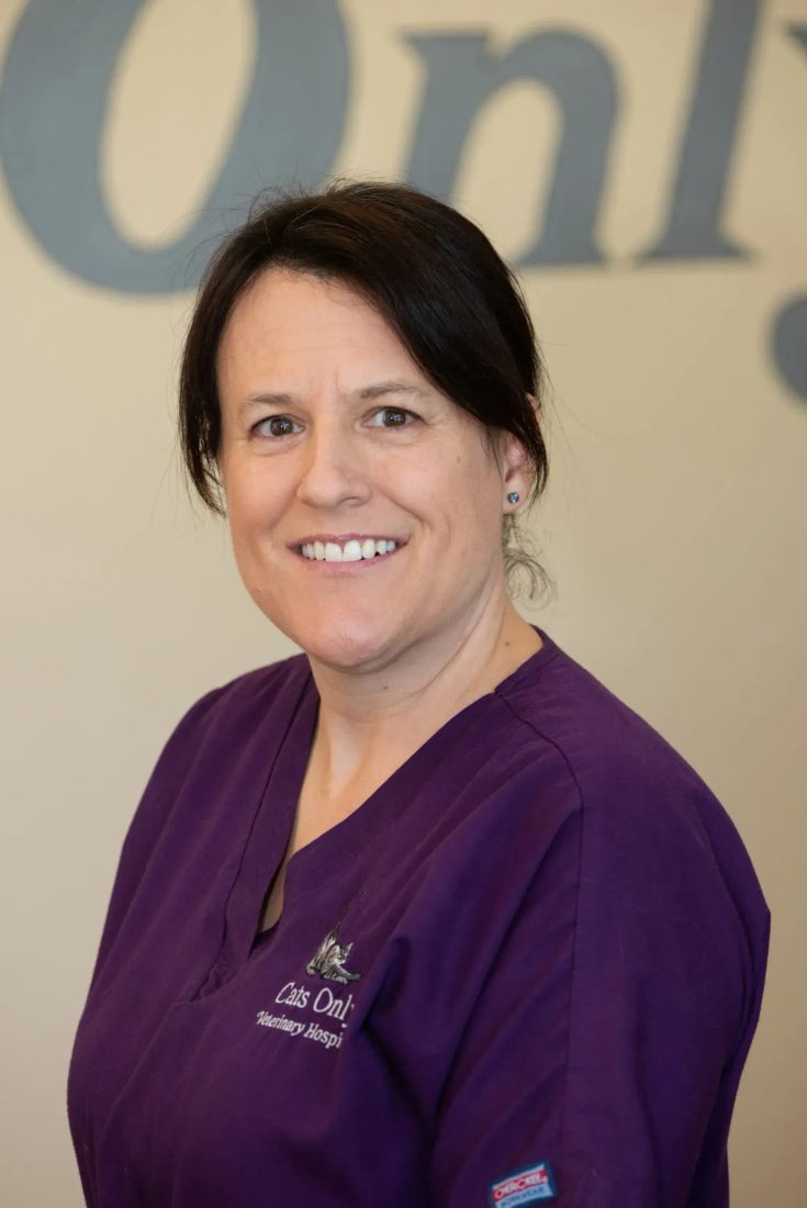 Smiling staff member in purple scrubs at Cats Only Veterinary Hospital